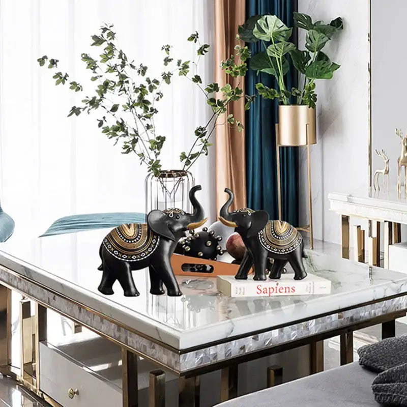 Black elephant sculpture figurines with gold and bronze patterns on their backs for living room decor use