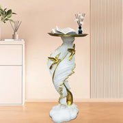 White and gold feather floor decoration side table with golden hummingbirds and an open book on its circular top