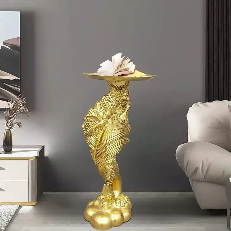 White and gold feather floor decoration pedestal with golden leaf design and open book on curved top for living room use