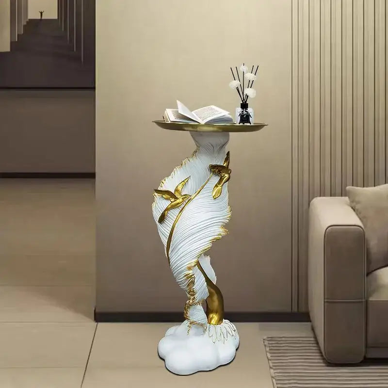 White and gold feather floor decoration side table with curved design and golden bird accent supporting a brass tray