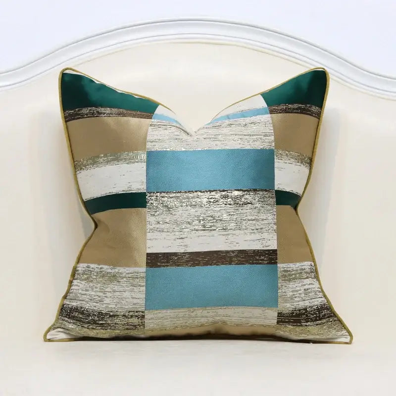 A white and gold jacquard luxury cushion cover with teal beige silver stripes and gold piping for living room decor