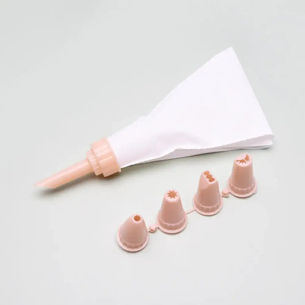 Pink plastic decorbites cake cream decorating gun with white paper liner and matching pink silicone nozzles set