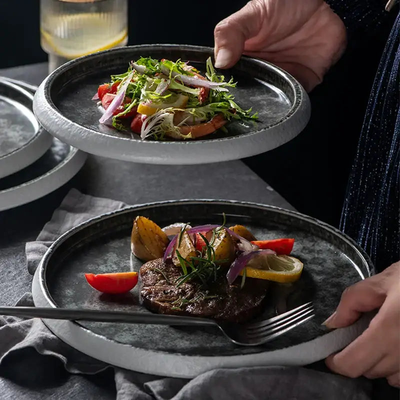 Dark gray ceramic plates with rustic textured finish and white rims in decorbites ice cracked glaze dinnerware set
