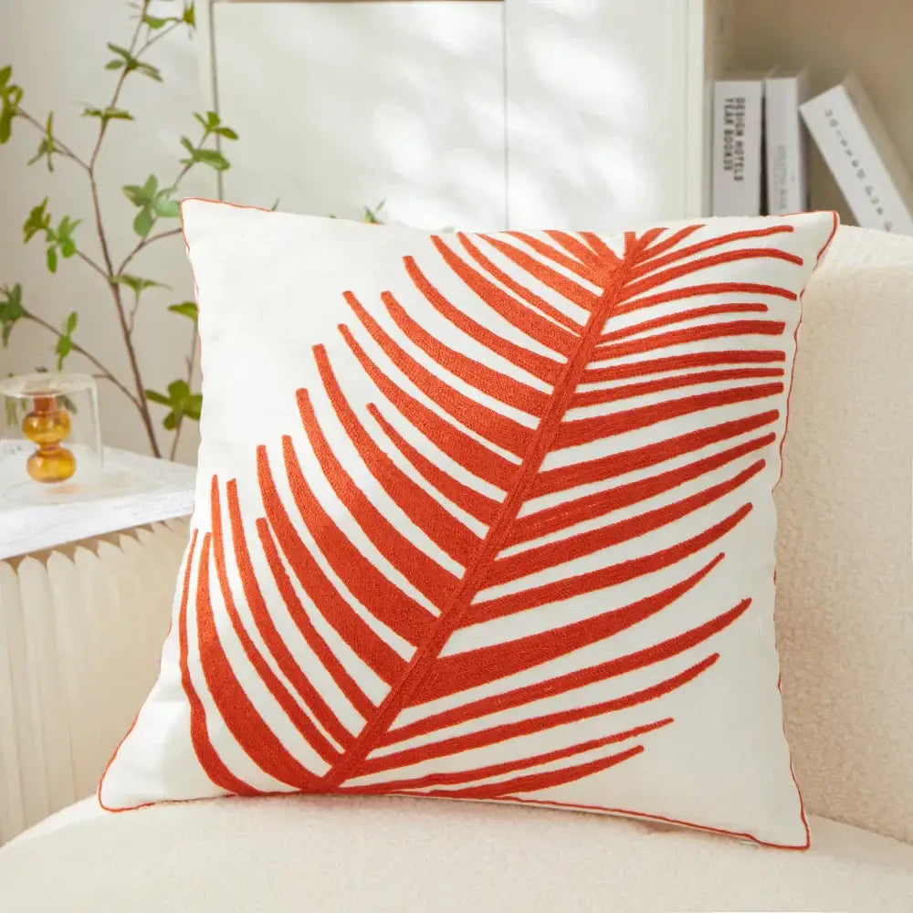 White pillow cover with bold orange embroidered leaf design for living room decor