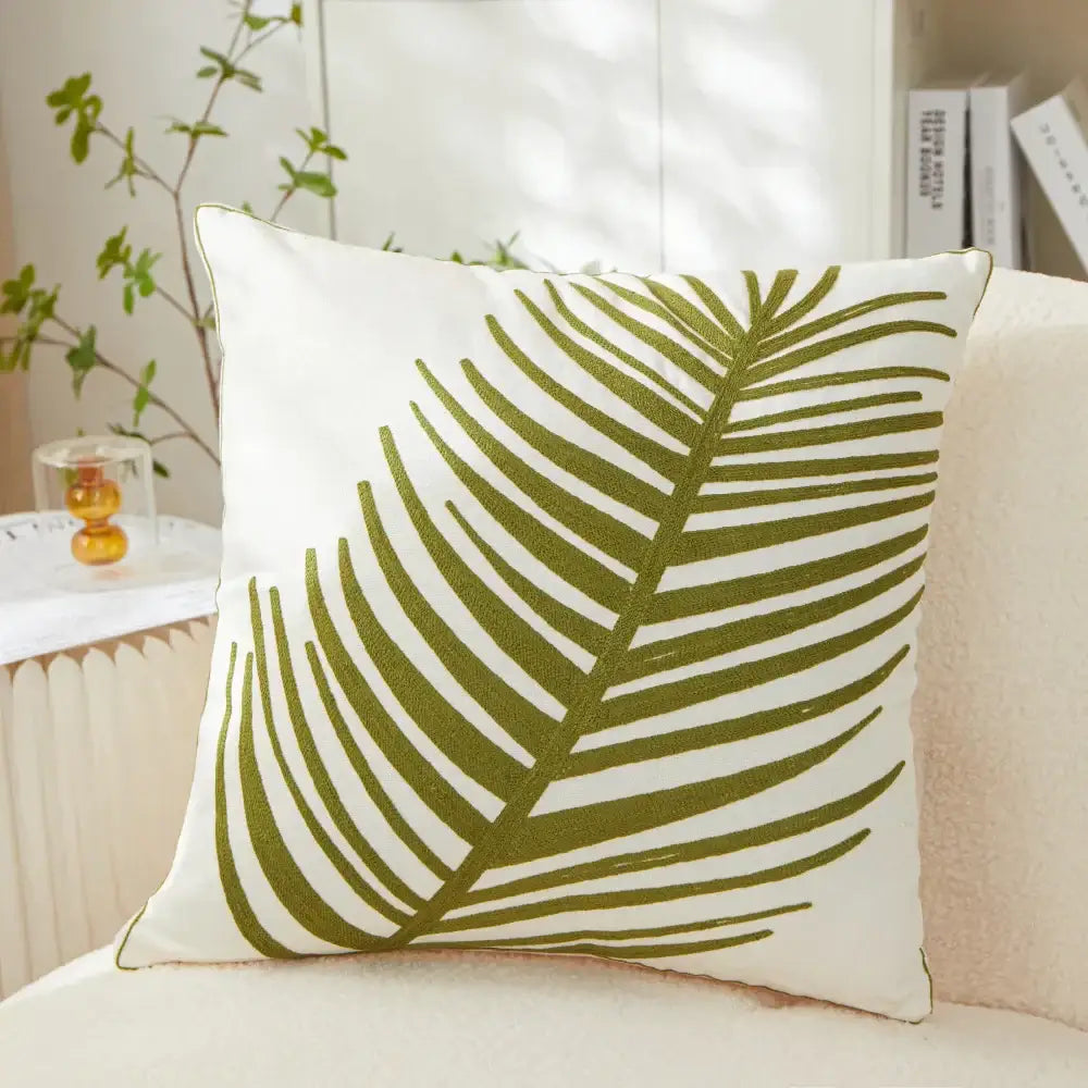 White pillow cover with olive green embroidered leaf design for living room decor featuring embroidered leaf pillow style