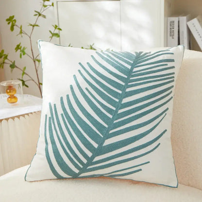 White pillow cover with teal embroidered leaf design ideal as an embroidered leaf pillow for living room decor
