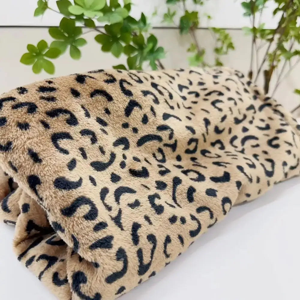 A plush white and orange leopard print warm fleece blanket with soft fuzzy texture for cozy bedroom decorbites leopard print