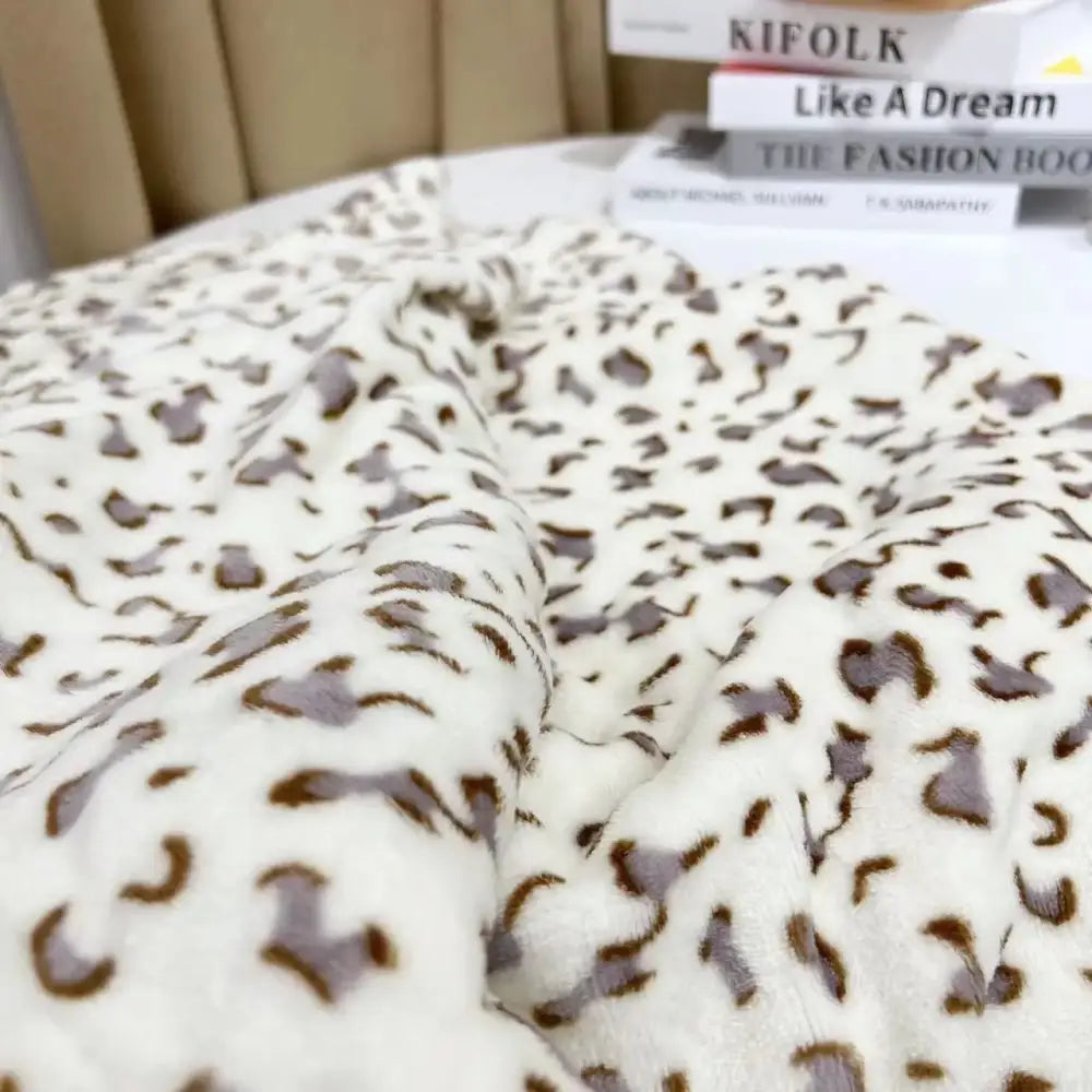 A white and orange leopard print warm blanket with plush fleece and soft fuzzy texture for cozy decorbites leopard print decor