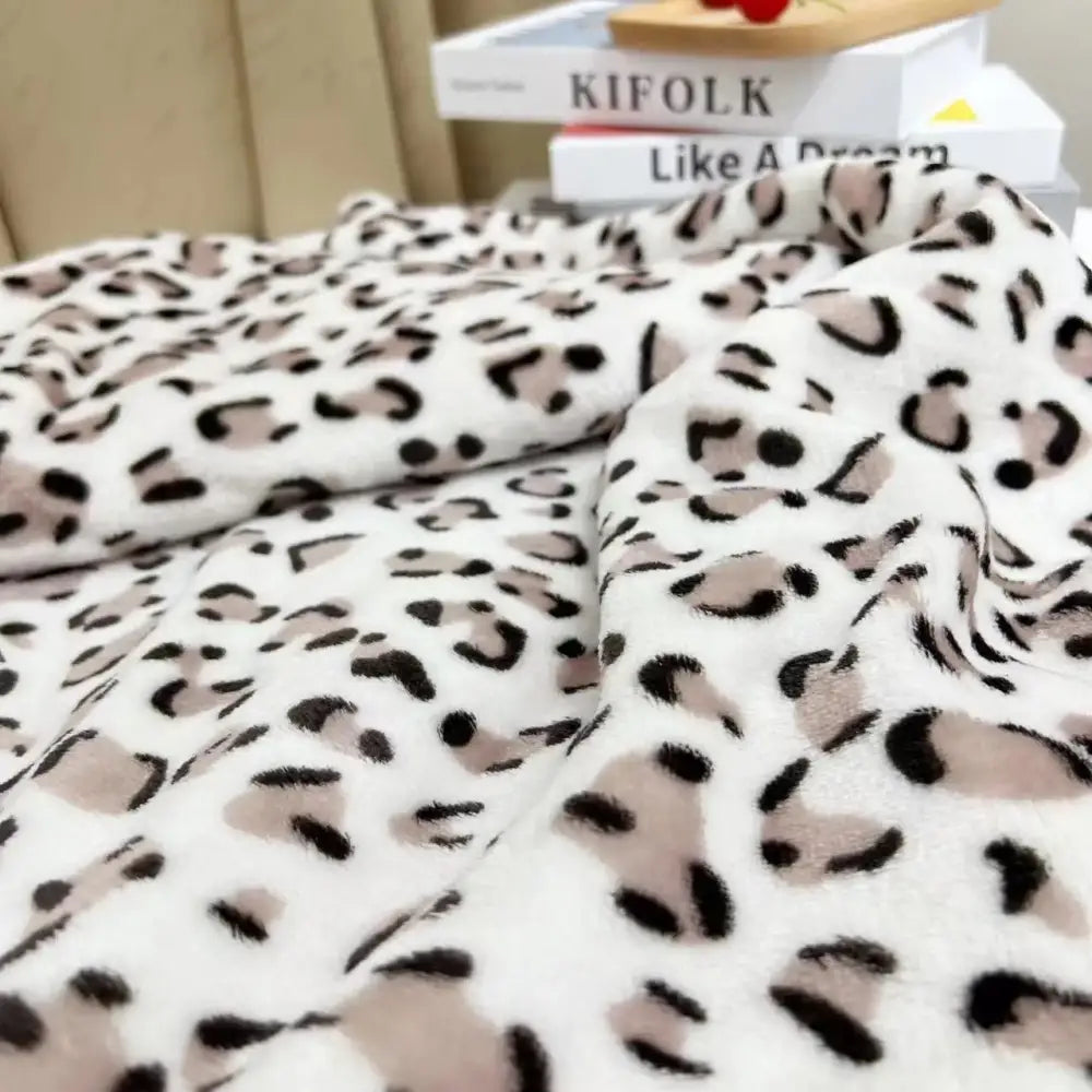 A plush white and orange leopard print warm fleece throw blanket with soft fuzzy texture for cozy decorbites leopard print decor