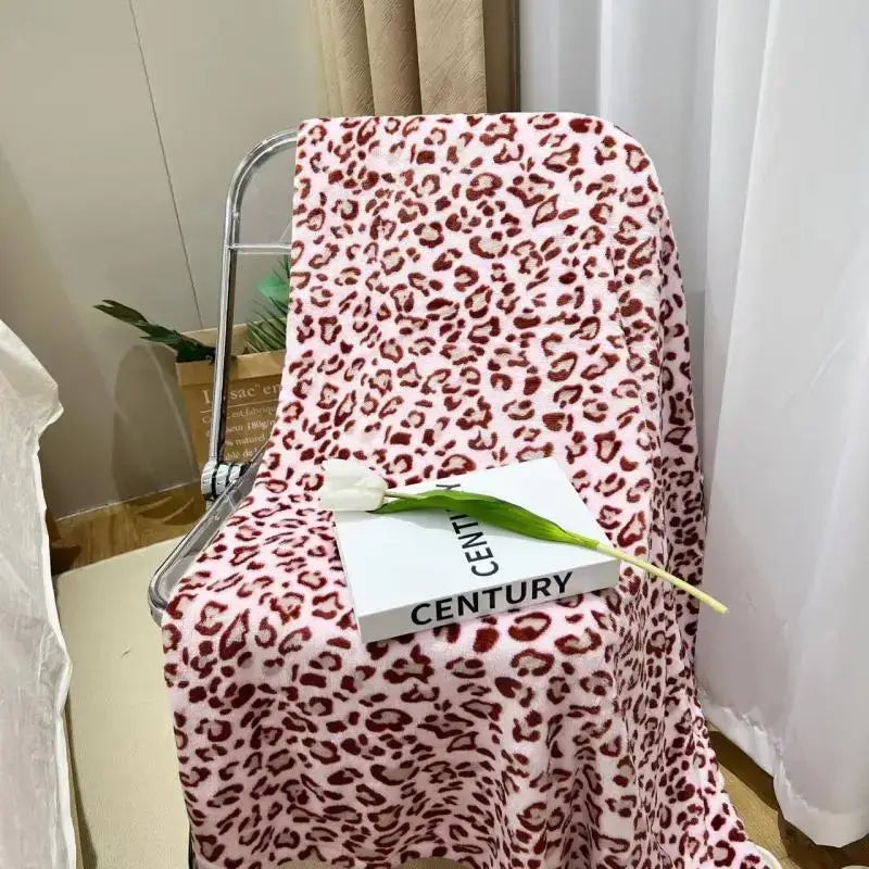 Pink leopard print fleece blanket draped over metal chair soft warm decorbites leopard print bedroom throw
