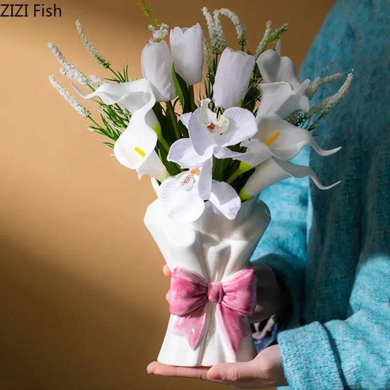 White and pink bowknot ceramic vase by decorbites shaped like a dress holding artificial white flowers for living room decor