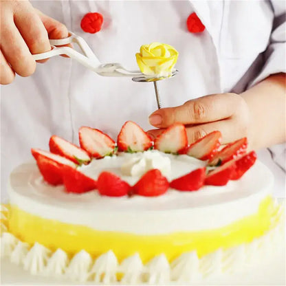 A delicate yellow icing rose is placed on a cake using a white and pink decorbites cream flower scissors set for decorating