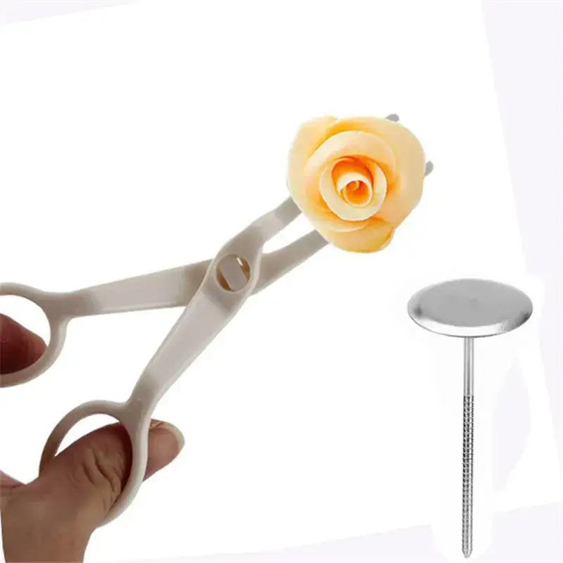 White plastic cream flower scissors holding a yellow fondant rose from decorbites cream flower scissors set