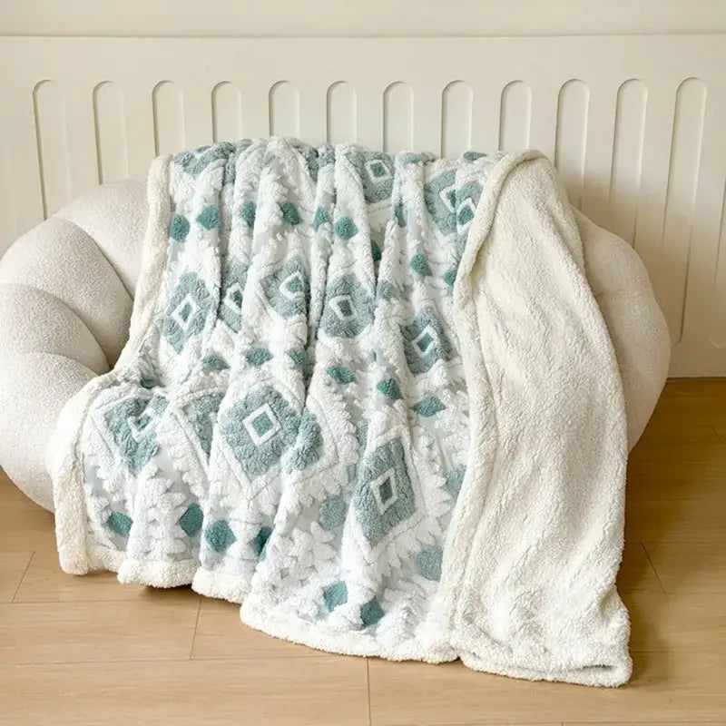 A plush white and teal geometric jacquard taff velvet throw blanket with soft textured surface for bedroom decorbites decor