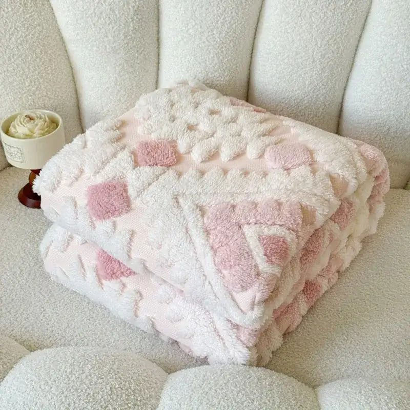 A plush white and pink geometric jacquard taff velvet blanket with a textured pattern ideal for bedroom decorbites throw
