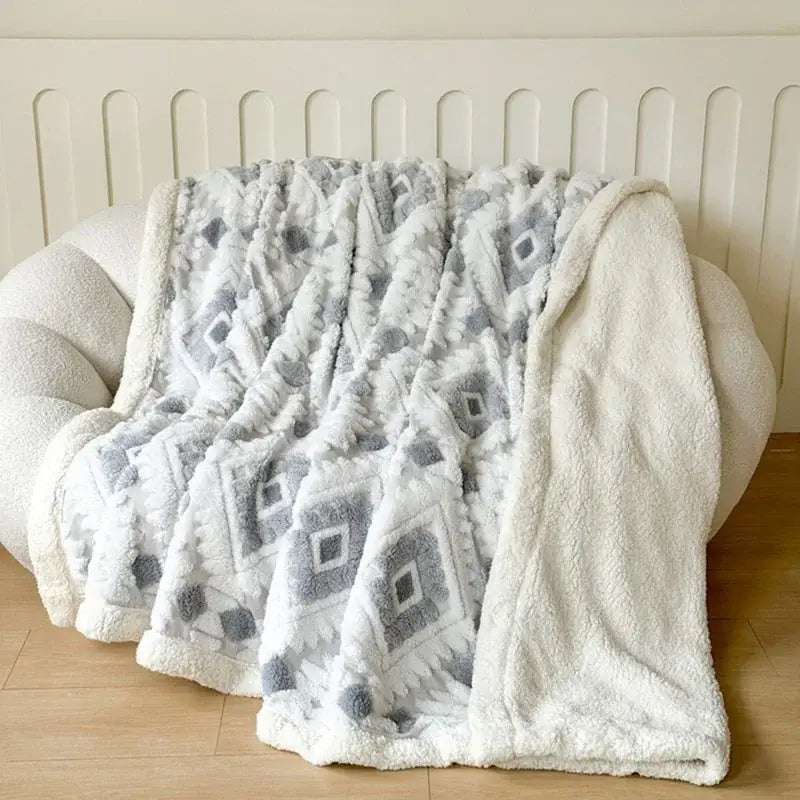 A plush white and gray geometric jacquard taff velvet throw blanket with soft fuzzy texture for bedroom decorbites decor