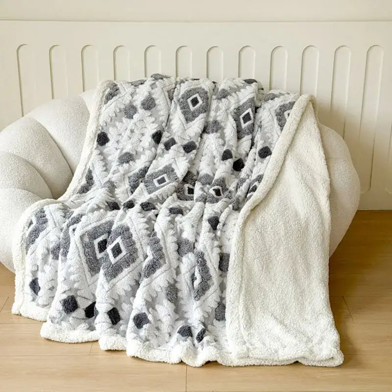 A plush white and gray geometric jacquard taff velvet throw blanket with a soft textured surface for bedroom decor