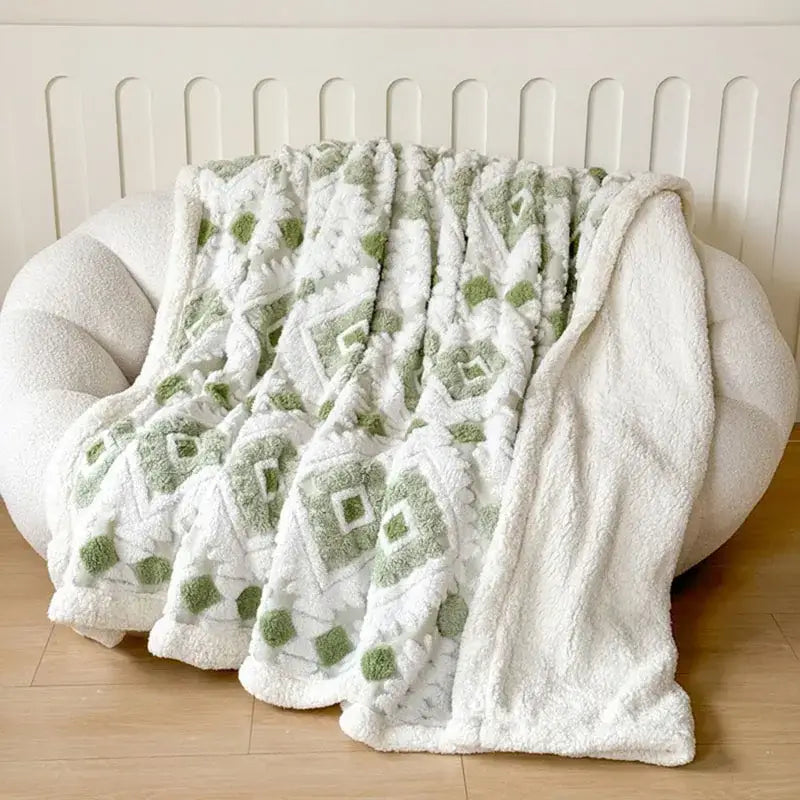 A plush white and sage green decorbites geometric jacquard taff velvet throw blanket with a soft textured surface