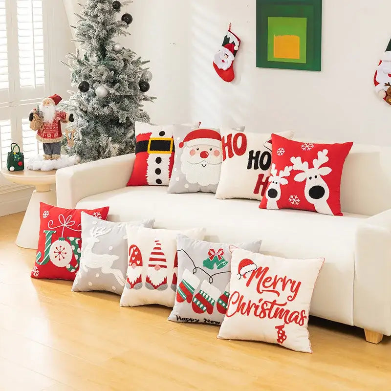 A collection of white and red decorbites embroidered christmas pillow cases featuring santa and reindeer designs