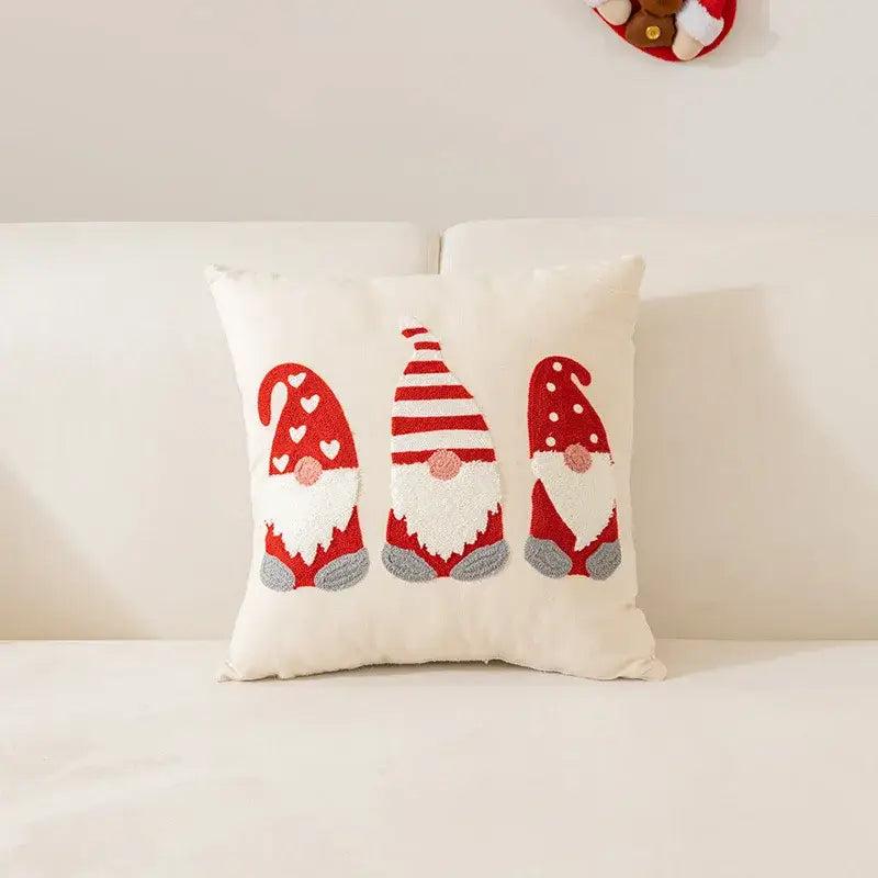Cream-colored decorbites embroidered christmas pillow featuring three gnomes in red white and gray festive hats