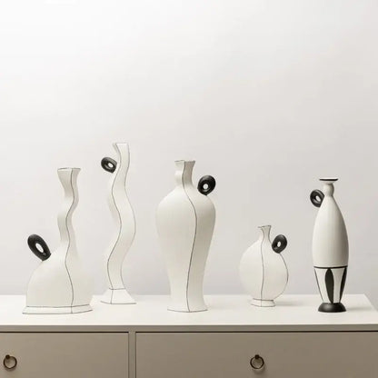 A set of six minimalist white ceramic vases with geometric black lines and black circular accents for living room decor