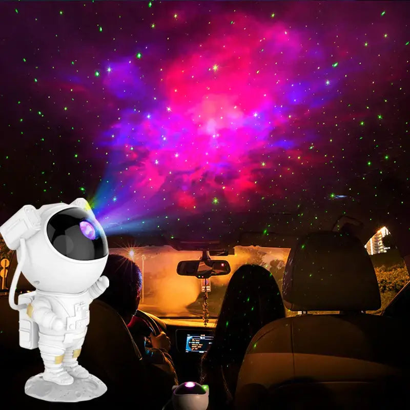 White astronaut star projector night light casting vibrant pink purple and green starry sky on car ceiling