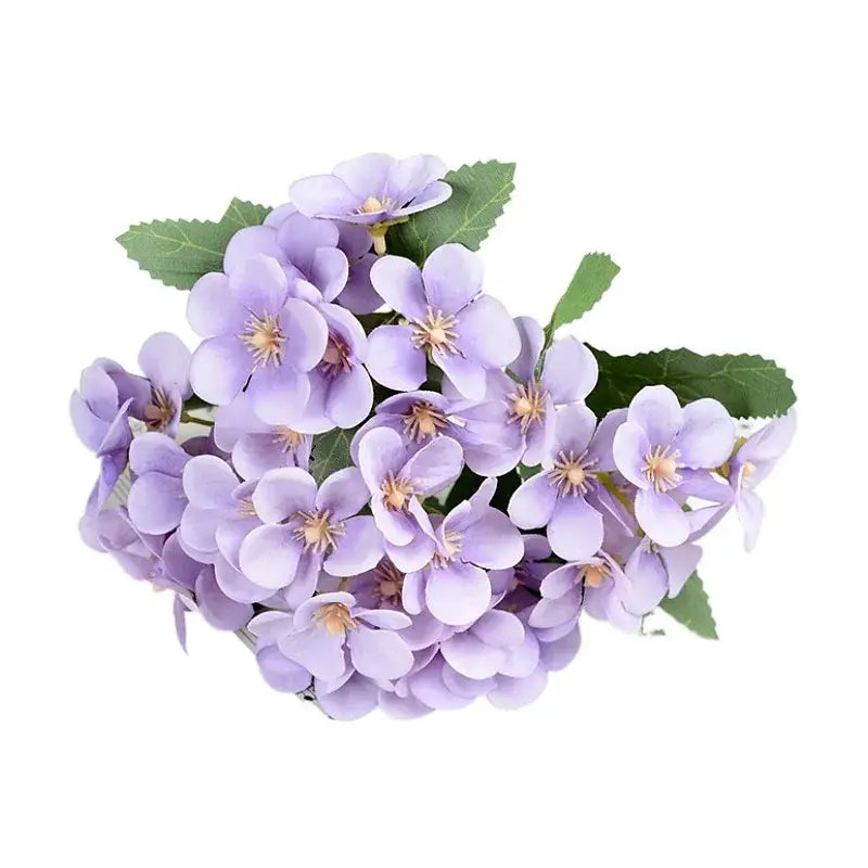 A delicate lavender silk flower bouquet featuring artificial hydrangea flowers in a white begonia silk flower vase decor