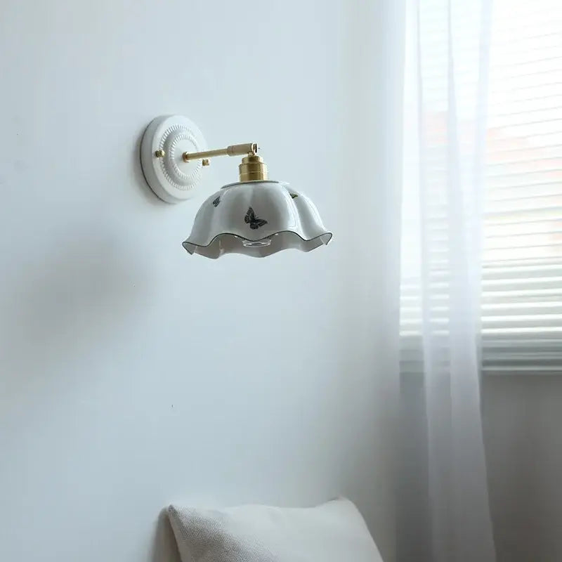 White butterfly ceramic led wall lamp with gold-toned arm and ruffled shade featuring subtle butterfly ceramic led decals