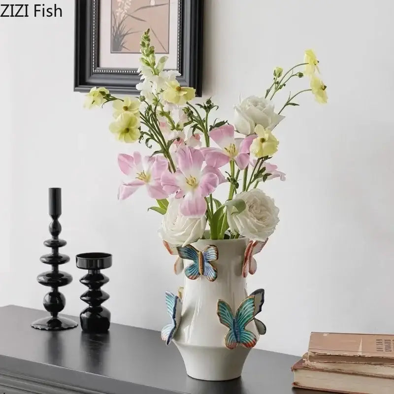 White butterfly ceramic vase by decorbites with colorful butterfly decorations holding pink yellow and white flowers decor