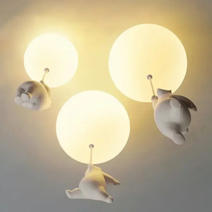 White ceramic bear pendant light featuring three whimsical off-white ceramic balloon bears hanging from spherical fixtures