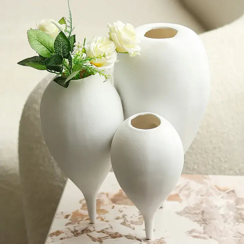 Three white ceramic balloon geometric vases with slender teardrop shapes in a geometric vase trio for living room decor