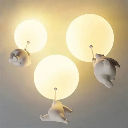 White ceramic bear cartoon pendant lamp featuring three whimsical bear-shaped lights holding glowing bulbs for kids bedroom