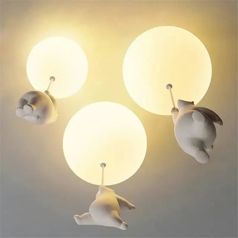 White ceramic bear cartoon pendant lamp featuring three whimsical bear-shaped lights holding glowing bulbs for kids bedroom