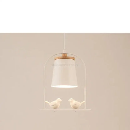 White ceramic bird led pendant light with wooden accent and two small bird figurines for dining room decorbites pendant light