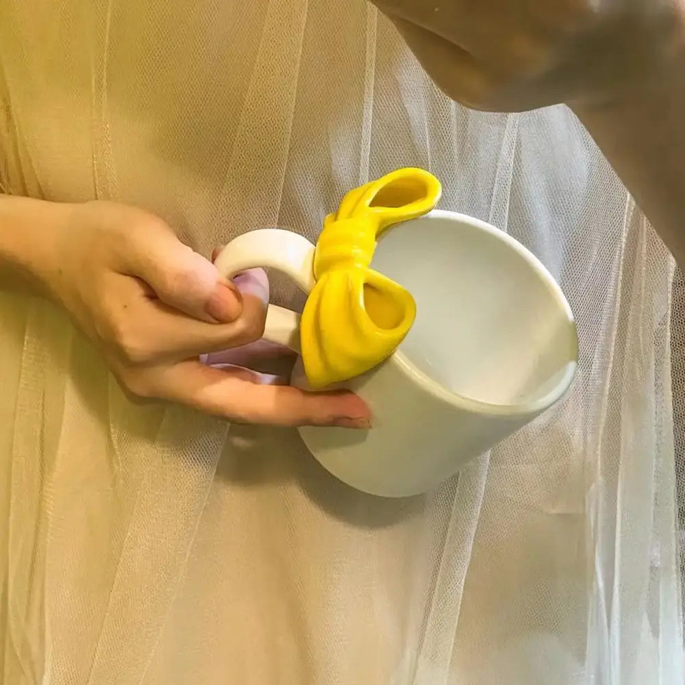 White ceramic bow knot mug with bright yellow decorbites bow knot ceramic handle accent for dining room use