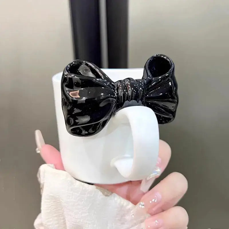 White ceramic bow knot mug with a glossy black decorbites bow knot ceramic accent on the rim for dining room use