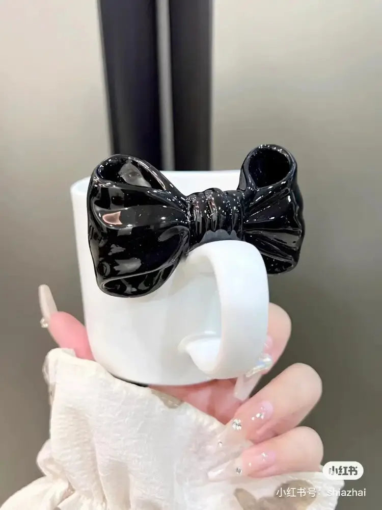White ceramic bow knot mug featuring a glossy black bow knot ceramic accent for elegant dining room decorbites use