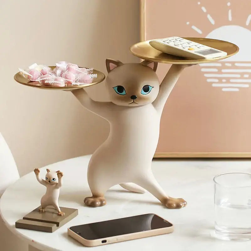 Cream-colored ceramic cat tray sculpture with blue eyes balancing two gold trays for office desk storage accessory