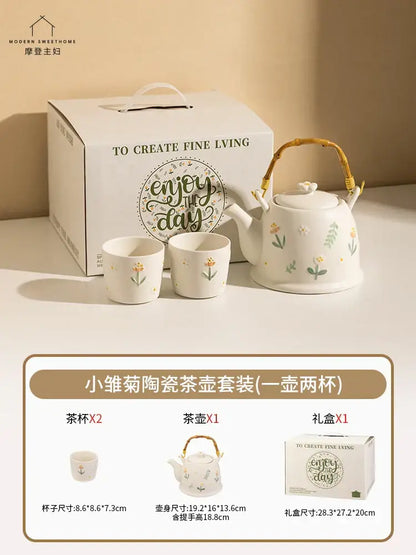 White ceramic daisy teapot set with delicate floral decals and a woven bamboo handle for kitchen use