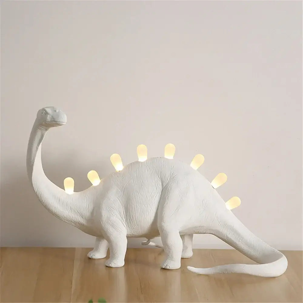 White ceramic dino led desk lamp with glowing yellow lights along its back for bedroom decorbites dino led lighting