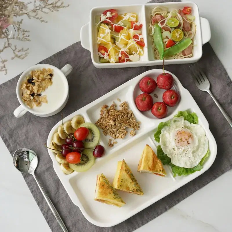White ceramic divided plate tray with segmented compartments holding various foods by decorbites ceramic divided