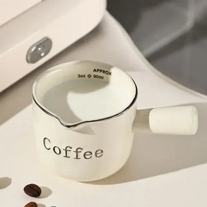 White ceramic espresso measuring cup and milk pitcher with silver rim and handle marked coffee for decorbites espresso measuring