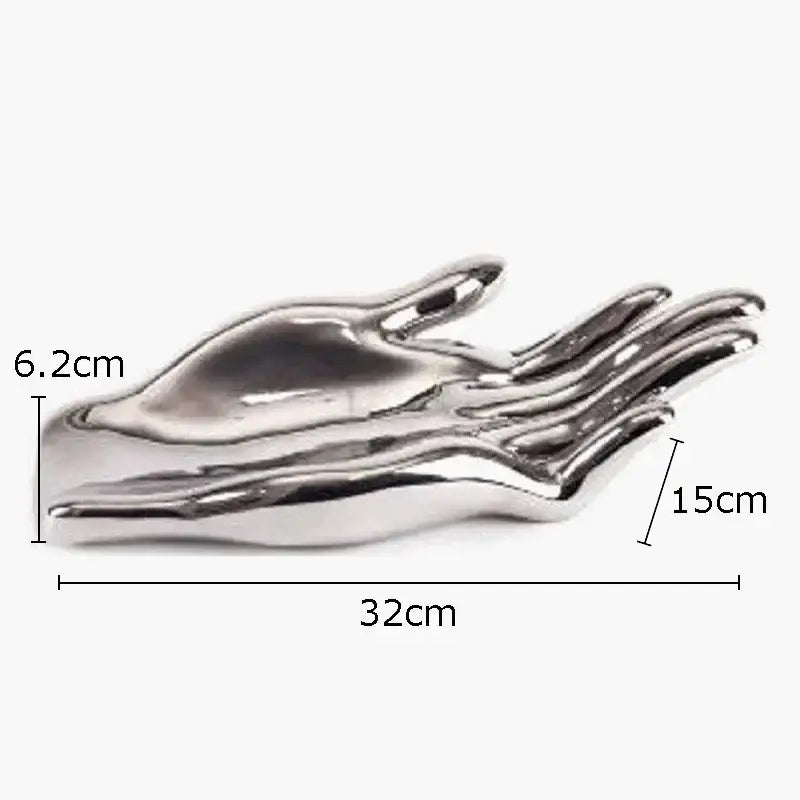 Shiny silver metallic sculpture of an open hand serving as a decorative fruit plate tray for living room decor