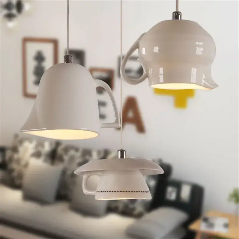 Three white ceramic led pendant lights shaped like teapots and mugs glow warmly for kitchen dining room decorbites ceramic led