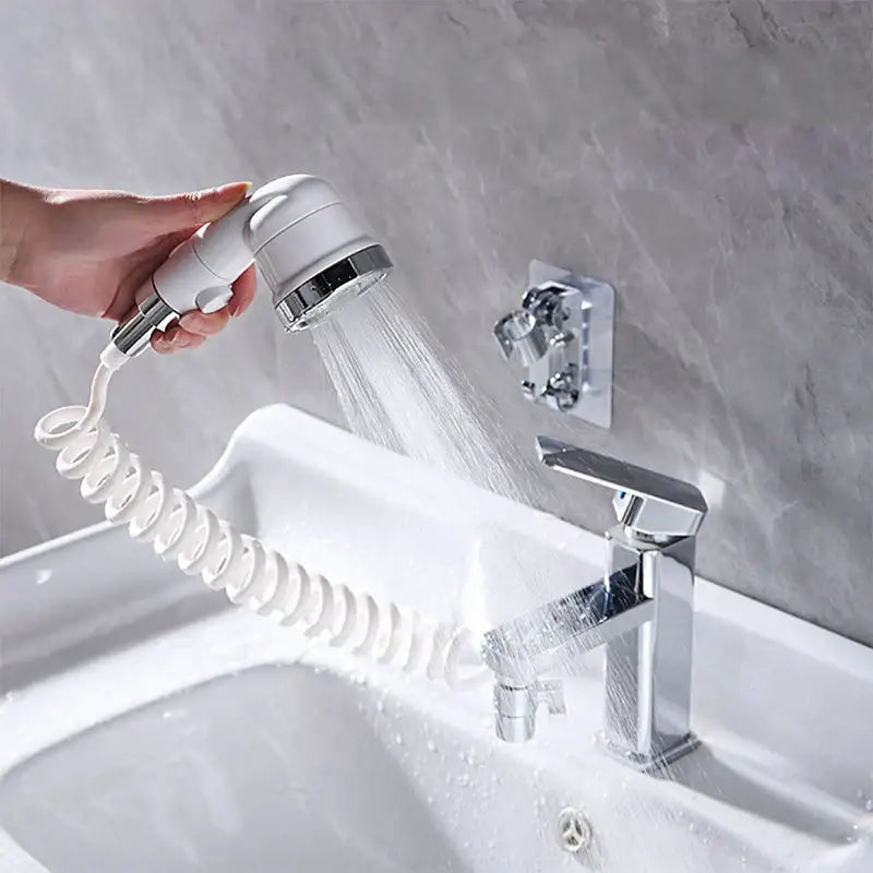 White and chrome handheld shower nozzle with coiled hose attached to modern bathroom sink faucet for handheld shower use
