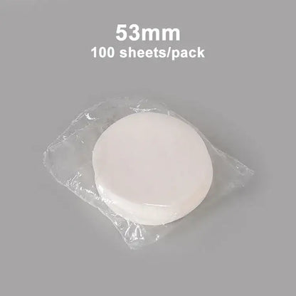 A stack of 53mm white circular disposable coffee filter papers in clear packaging for decorbites coffee filter use