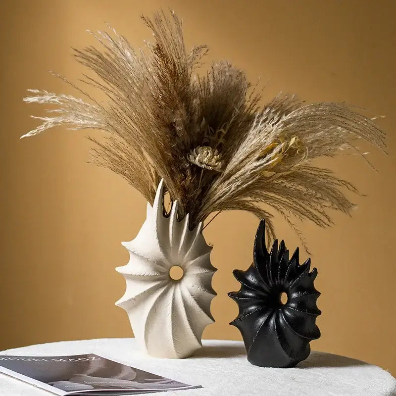 White and black conch shape ceramic vases holding dried pampas grass for living room artificial flower arrangements