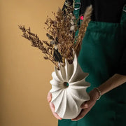 White conch shape ceramic vase with spiral petal design and central hole for living room artificial flower arrangements