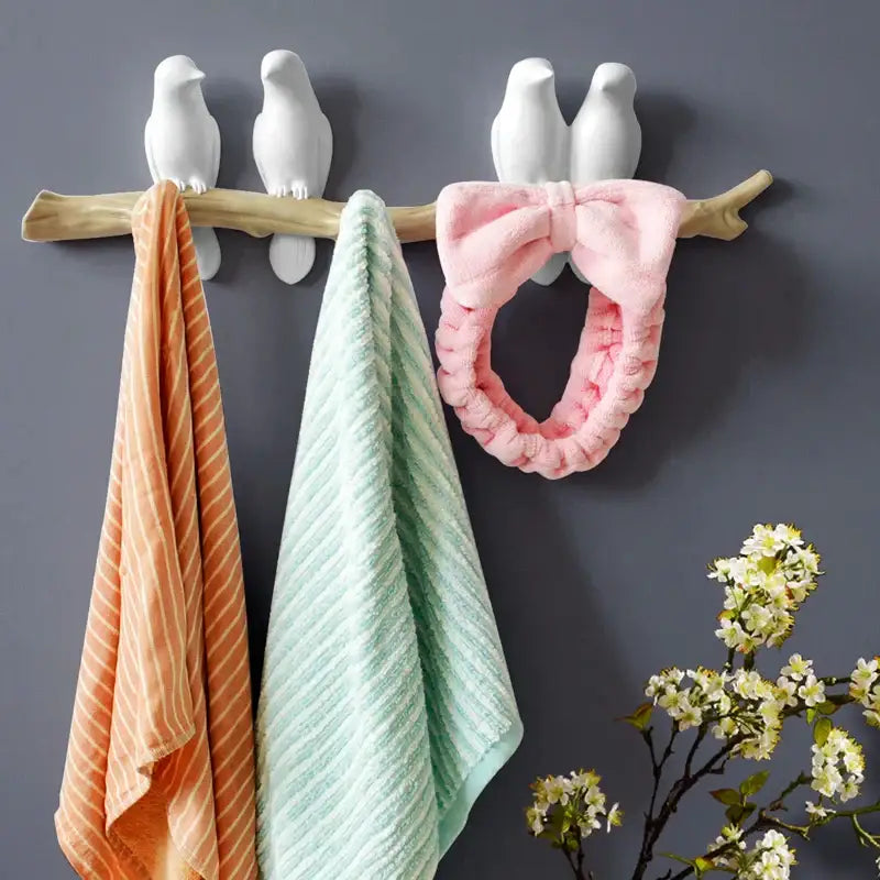 Pink plush headband with large bow hanging on white decorbites bird resin hanger kitchen hook on wooden branch