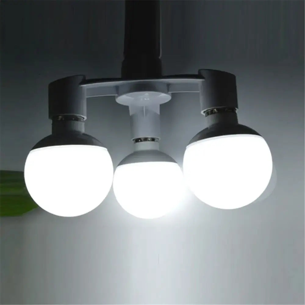 Three spherical led light bulbs with frosted glass shades and black fixtures on a white e27 lamp 3-way converter pack